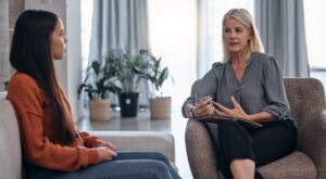 Woman asking her therapist about the benefits of TMS vs neurofeedback