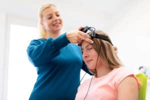 Woman receiving neurofeedback therapy in TMS vs neurofeedback therapy study