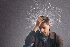 A man holding his head, showing signs of ADHD in adults